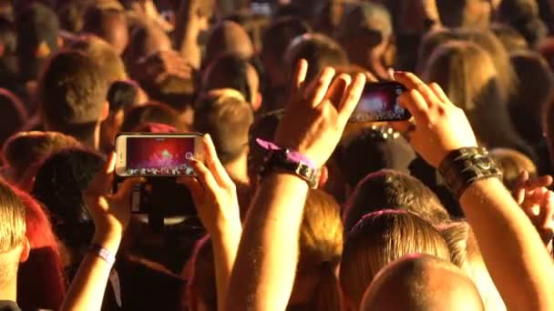 Фанаты снимают видео рок-концерт на мобильные телефоны . — стоковое видео