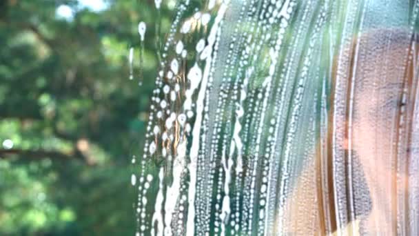 Young attractive woman washes a window using a special brush. Dolly shot. — Stock Video