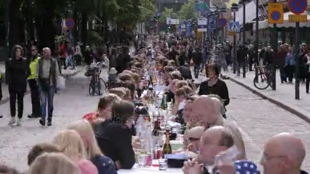 Wiele osób, jedząc i pijąc przy tym samym stole, na ulicy. Upływ czasu. — Wideo stockowe