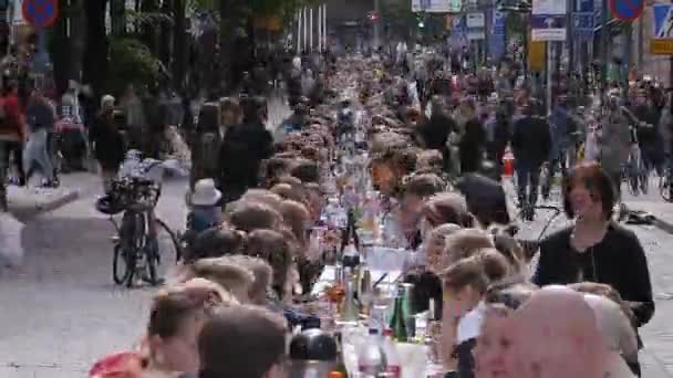 Een heleboel mensen eten en drinken aan dezelfde tafel op straat. Time-lapse. — Stockvideo