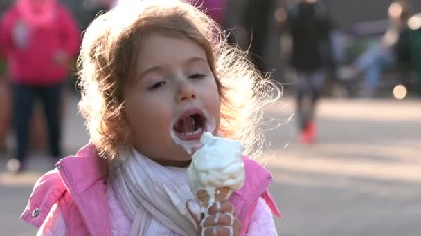 Aranyos kisgyermek lány eszik fagylaltot a Városligetben. Lassú mozgás. — Stock videók