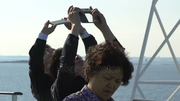 Toeristen uit China enthousiast het nemen van foto's van de meeuwen aan boord van de veerboten. — Stockvideo