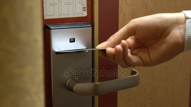 Uma jovem abre a porta de seu quarto de hotel usando um cartão eletrônico . — Vídeo de Stock