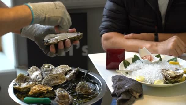 Chef-kok opent oesters voor bezoekers van het restaurant. — Stockvideo