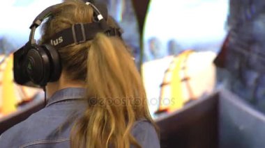 Sanal gerçeklik oyunu. Kız baş takılı ekran kullanır