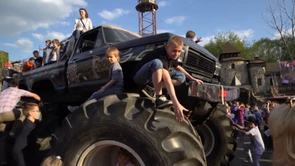 Dzieci wspinać się ogromny monster truck. — Wideo stockowe
