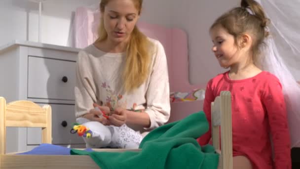Una joven madre tomando las baterías usadas de los juguetes y una niña poniéndolas en una caja de reciclaje en casa. Residuos domésticos de separación. Baterías solamente . — Vídeo de stock