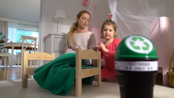 Mãe levando as baterias usadas de brinquedos, criança colocando-os em caixa de reciclagem. Movimento lento — Vídeo de Stock