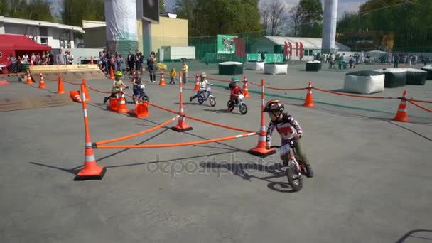 Little racers. Children ride bicycles on distillation in a city Park. — Stock Video