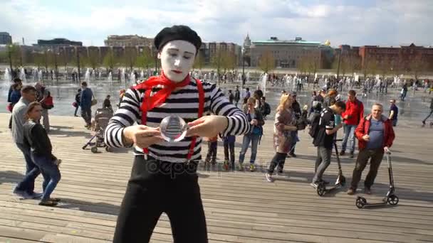 A street mime with a crystal ball stands in city park. — Stock Video