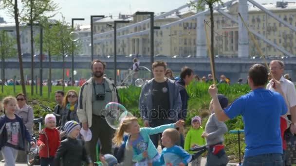 Děti si hrají v městském parku s velké mýdlové bubliny. — Stock video