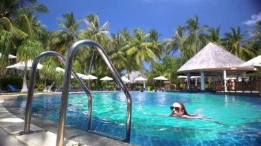 Yüzme Havuzu bir tropikal tatil üzerinde ince bir genç kadının.