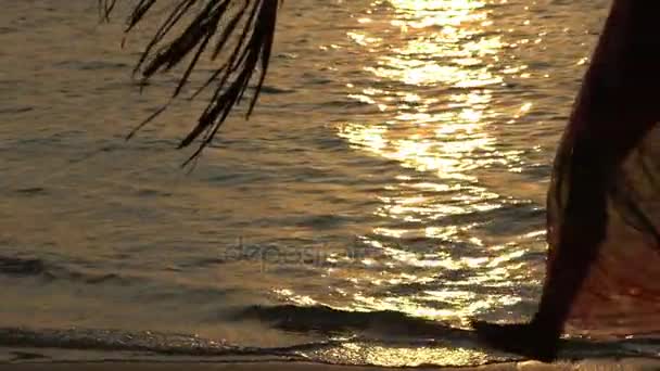 Žena chůze podél linie surf. Západ slunce na moři. Zpomalený pohyb. — Stock video