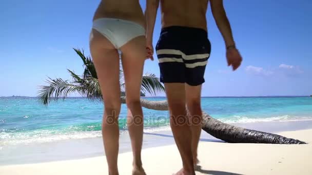 Egy szerető pár élvezi a nyaralás egy trópusi tengerparton. Lassú mozgás. — Stock videók