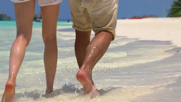 Pár séta a tengerparton. Közelkép a láb és a hullámok. — Stock videók