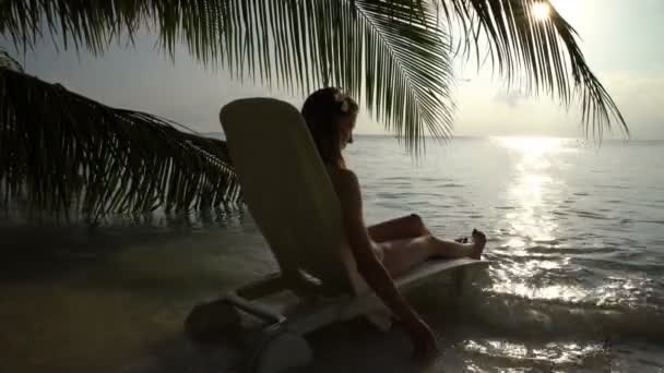 Jovem mulher magra desfrutando do pôr do sol na praia tropical . — Vídeo de Stock