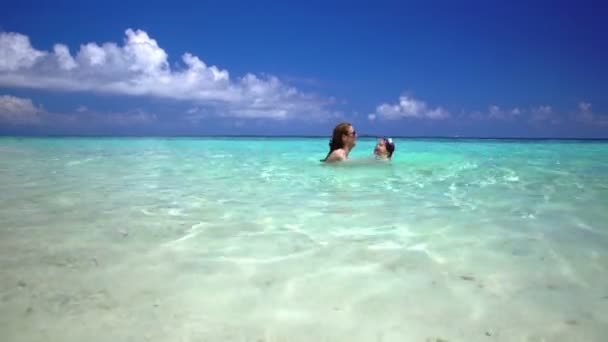 Moeder met haar dochter spelen in turquoise golven van de zee. — Stockvideo