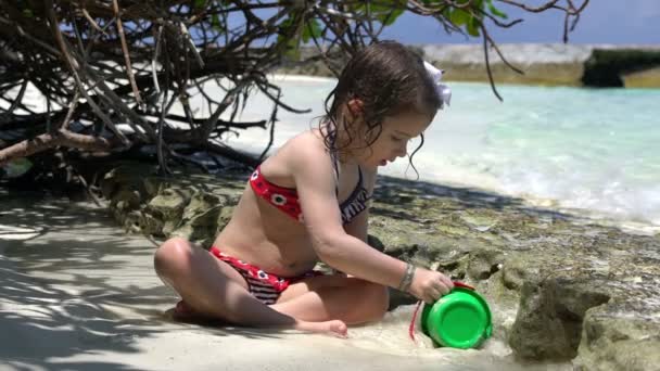 Meisje speelt met golven van de zee op een tropisch strand. Slow motion. — Stockvideo