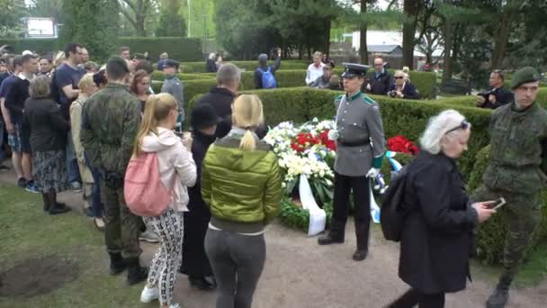 Eren wacht bij het graf van de Voorzitter. Mensen leggen bloemen op het graf van Mauno Koivisto. — Stockvideo