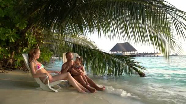 Genç bir aile küçük bir çocukla dondurma tropik sahilde zevk. Ağır çekim. — Stok video