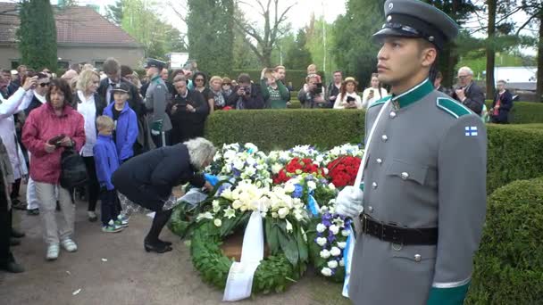 Respektovat stráž u hrobu prezidenta. Lidé položit květiny na hrob Mauno Koivisto. — Stock video