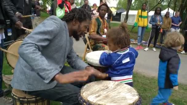 Μαύρο νέοι χορεύοντας, τραγουδώντας και παίζοντας τύμπανα σε ένα πάρκο της πόλης. — Αρχείο Βίντεο