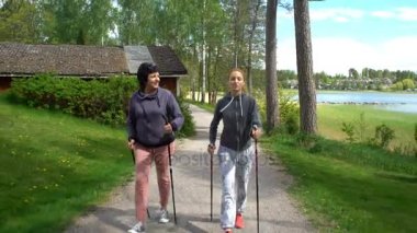 İki aktif kadın parkta yürüyüş yapmak. İzleme atış.