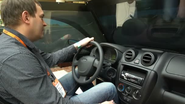 Un hombre utiliza un simulador de conducción del coche . — Vídeos de Stock