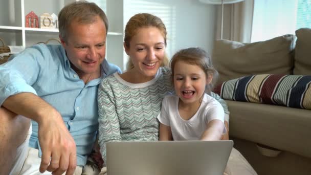 Сім'я з дитиною Використовуючи камеру відео виклику ноутбука — стокове відео