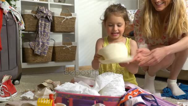 Petite fille avec des parents Emballage d'un bagage pour un voyage — Video