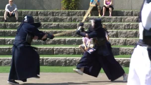 Бойцы Кендо тренируются драться с бамбуковым мечом синай в городском парке . — стоковое видео
