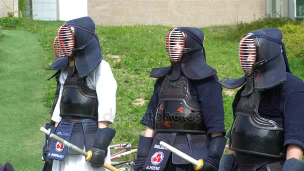 Kendo fighters practice fighting with a bamboo sword shinai in a city park. — Stock Video