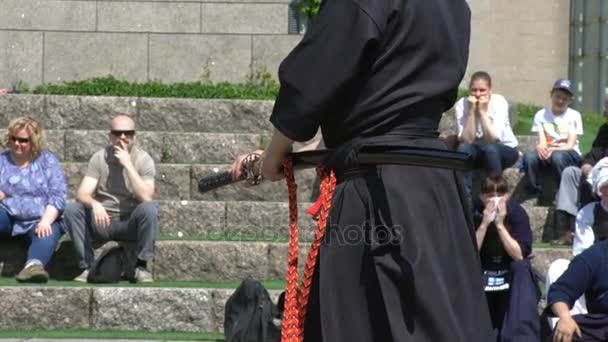 Молодые люди практикуют искусство японской борьбы с Иайдо в городском парке . — стоковое видео