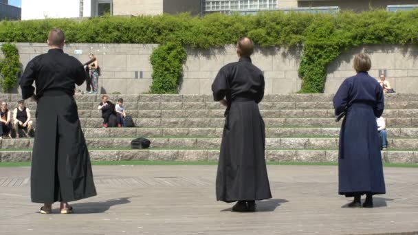 Молоді люди практикувати мистецтво японський бойовий іайдо в міському парку. — стокове відео