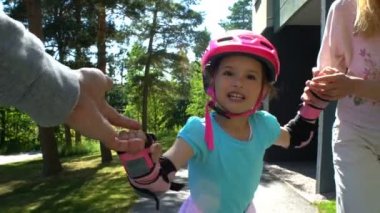 Anne küçük kızları tekerlekli paten kaymak için yardım