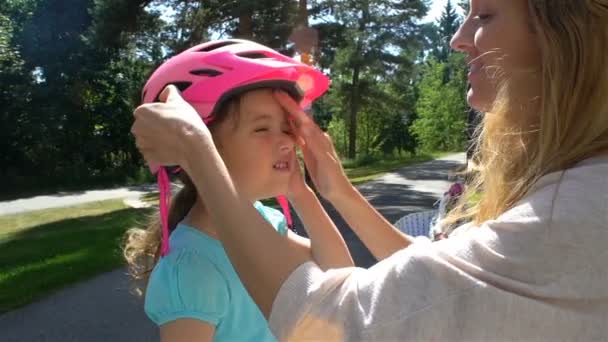 母の安全ヘルメットを置くは娘の小さな頭です。 — ストック動画