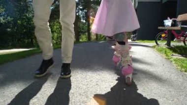 Annem küçük kızının paten kaymak için yardımcı olur