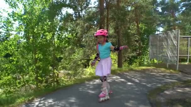 Mamá ayuda a su hijita a patinar en patines — Vídeos de Stock