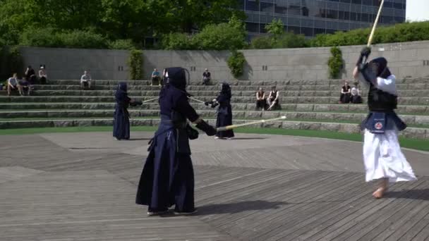 Combatientes Kendo practican la lucha con una espada de bambú shinai en un parque de la ciudad . — Vídeos de Stock