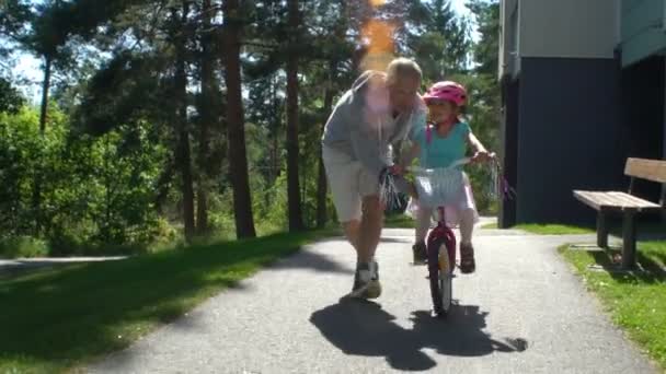 Папа учит свою дочь ездить на велосипеде — стоковое видео