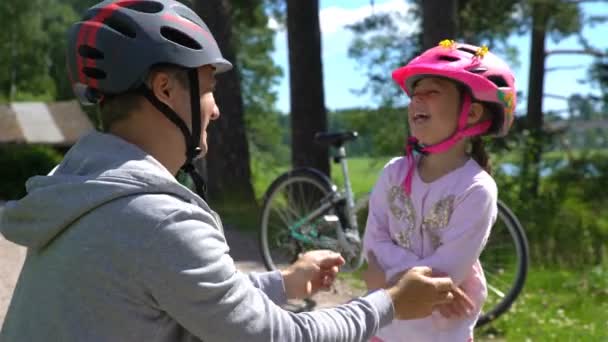 お父さんに安全ヘルメットを置くは娘の小さな頭です。 — ストック動画