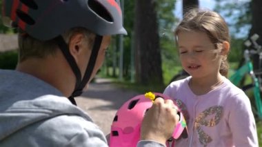 Baba koyar güvenlik kask üzerinde küçük kızları başıdır