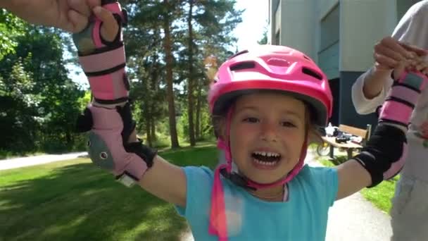 Rodiče pomáhají jejich malou dceru bruslit na kolečkových bruslích — Stock video