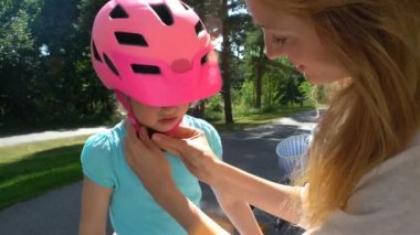 Anne koyar güvenlik kask üzerinde küçük kızları başıdır