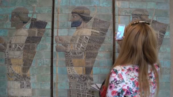 Junge Frau fotografiert mit dem Smartphone antike babylonische Basreliefs im Raster-Museum in Paris, Frankreich. — Stockvideo
