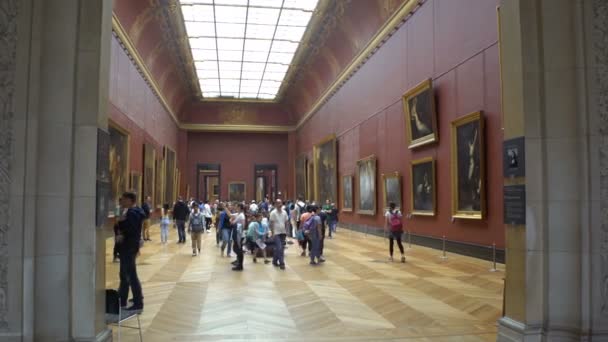 Mucha gente aprecia las pinturas y estatuas en el Museo del Louvre en París, Francia . — Vídeo de stock