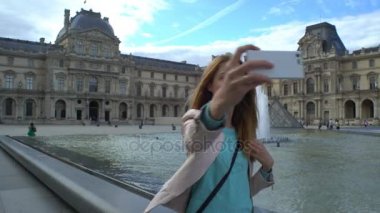 Mutlu kadın Selfie yapma bir Smartphone Paris Louvre de kullanır.