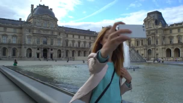 Happy Woman Making Selfie utiliza un teléfono inteligente en el Louvre de París — Vídeos de Stock