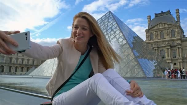 Happy Woman Making Selfie utiliza un teléfono inteligente en el Louvre de París — Vídeos de Stock