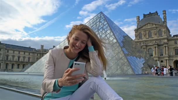 Happy Woman Making Selfie utiliza un teléfono inteligente en el Louvre de París — Vídeo de stock